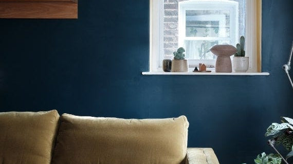 Cosy living room with deep blue walls painted in Farrow & Ball Hague Blue