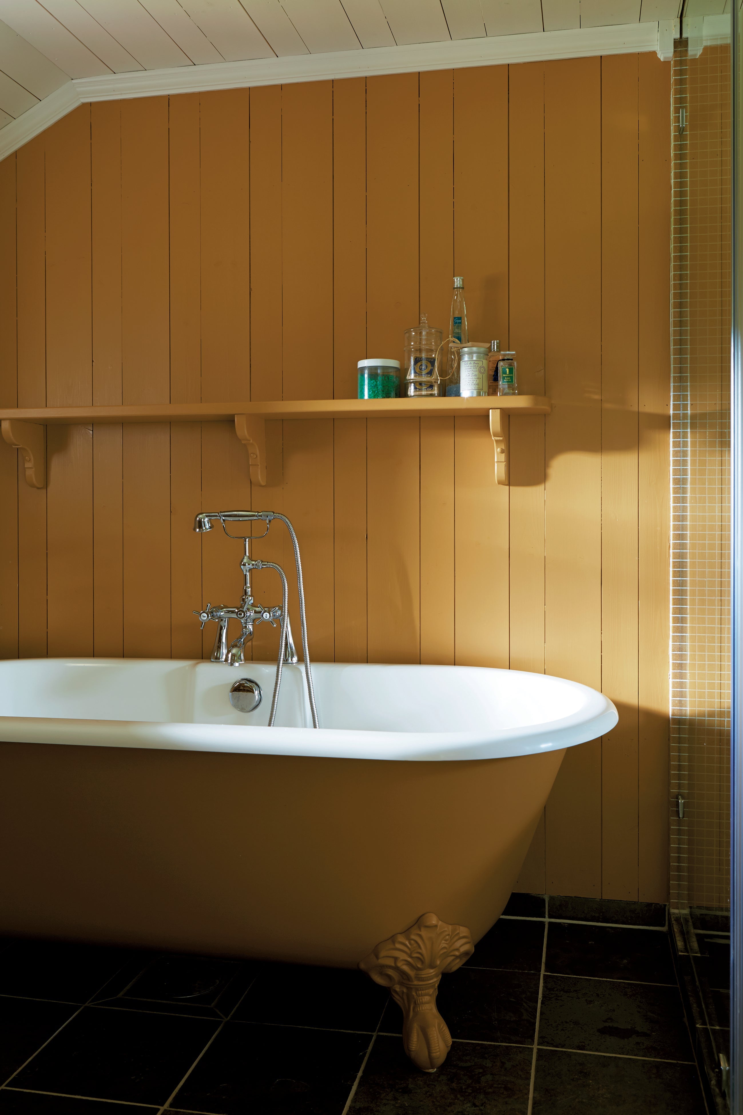Bathroom with panelling and roll top bath painted in Farrow & Ball India Yellow
